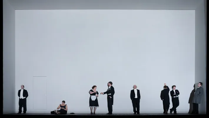 Svartklädda människor på scen mot en vit fond.