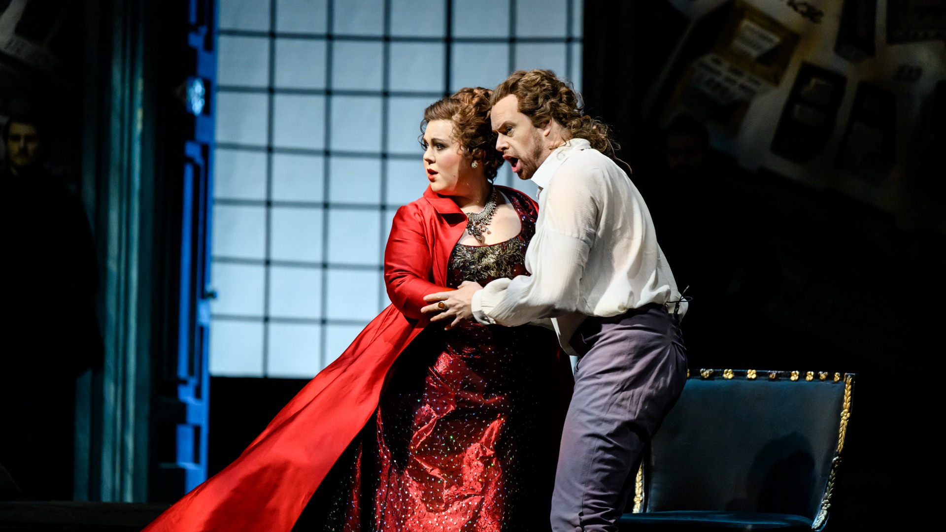 A woman in a red dress and a man are holding each other's hands.