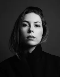 Närbild på en kvinna med mörkt hår som bär en mörk jacka.