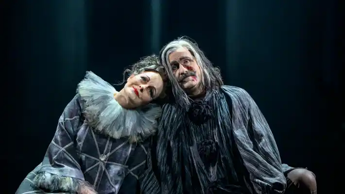 Några personer som sitter ner i kostym på scen.