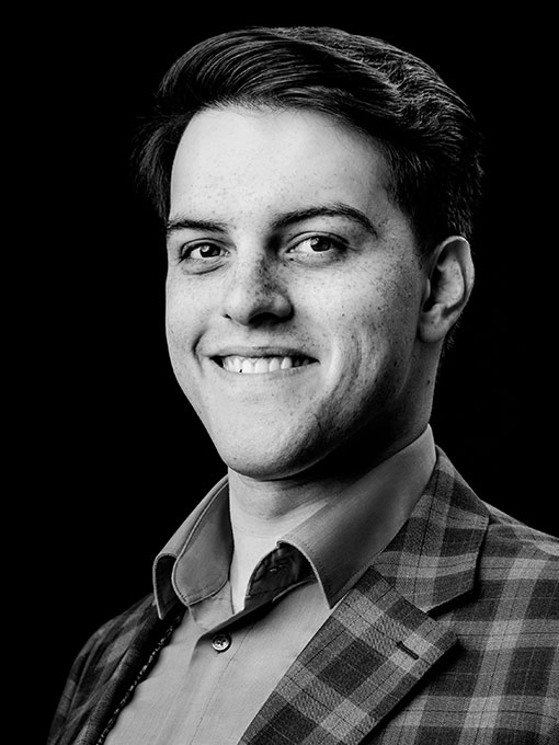 En närbild av en ung man med kort mörkt som ser rakt in i kameran.