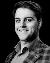 En närbild av en ung man med kort mörkt som ser rakt in i kameran.