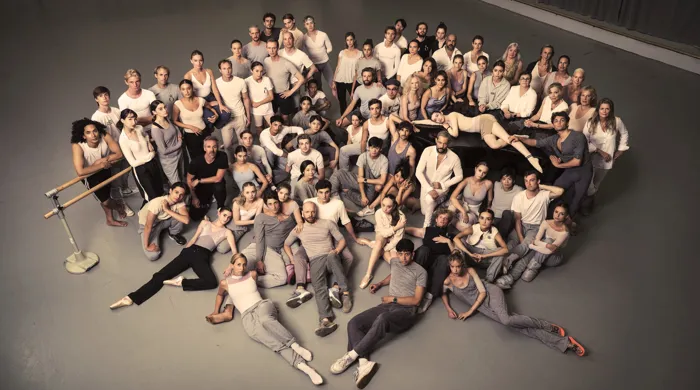 En stor samling människor som sitter och står, samlade i klunga.