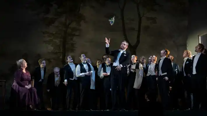 A man infront of a group of people on stage.