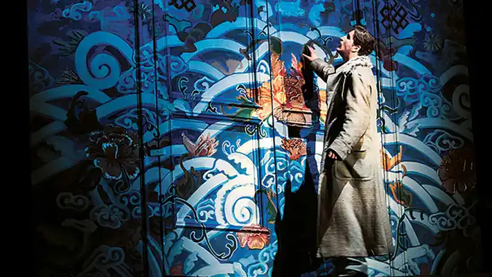 En man står vid en rikt utsmyckad stängd dörr.