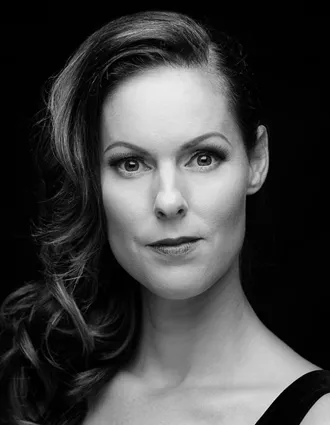 En närbild på en kvinna med långt böljande, mörkt hår över ena axeln.