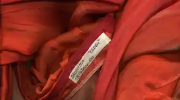 Detail of a costume made out of red fabric with a name tag.