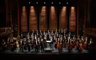 Många musiker står utspridda på en stor scen.