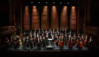 Många musiker står utspridda på en stor scen.