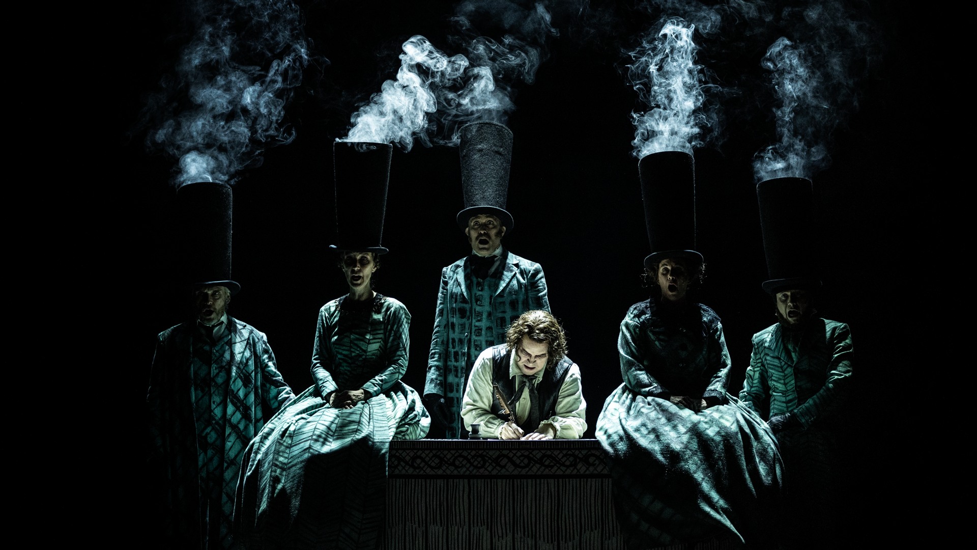 A group of people standing around a table, smoke rising from their hats.