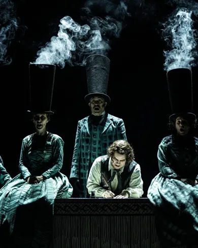 A group of people standing around a table, smoke rising from their hats.