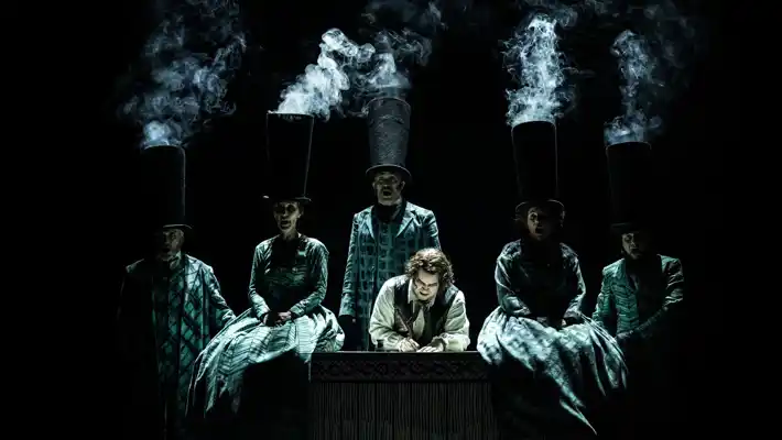 En grupp människor som står runt ett bord, rök stiger ur deras hattar.