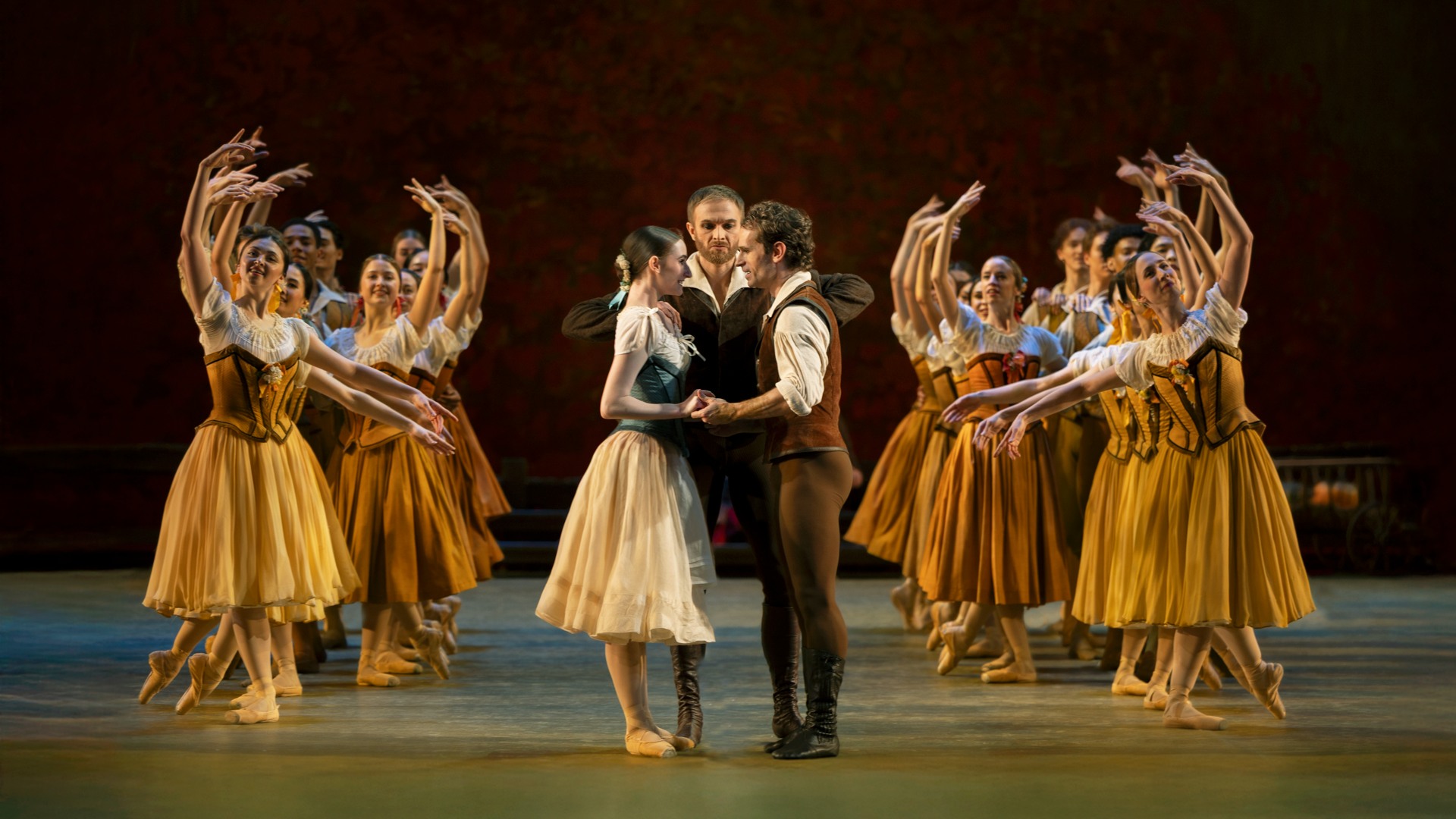 På en scen ser man i mitten ett ungt par, runt dem flera kvinnliga dansare.