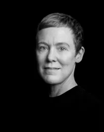 En närbild på en kortklippt kvinna i mörk tröja.