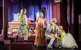 Fyra personer i ett rum, en man viftar med ett brev.