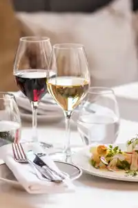 Ett dukat bord med mat och vin i höga glas.