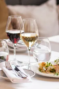 Ett dukat bord med mat och vin i höga glas.