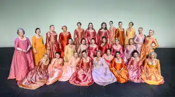 En samling kvinnor i sidenklänningar som står sitter mot en ljust grön bakgrund.