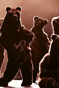 Several bears on a stage, one dancing, one playing a carillon.