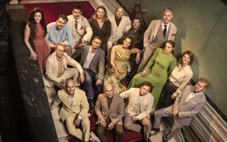 Flera personer står uppställda i en trappa, de tittar upp mot kameran.