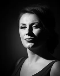 En närbild på en kvinna med mörkt och en urringad topp.