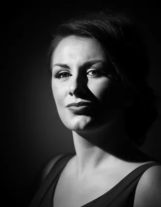 En närbild på en kvinna med mörkt och en urringad topp.