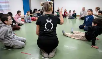 Unga Operan Operaworkshop Barn som sitter i ring på ett golv.